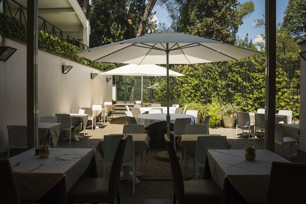 Outdoor dining terrace shaded by white umbrellas